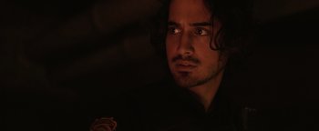 Movie still from “Resident Evil: Welcome to Raccoon City” (2021), directed by Johannes Roberts – A person with long curly hair; Close Up shot, Over the shoulder angle