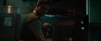 Movie still from “Resident Evil: Welcome to Raccoon City” (2021), directed by Johannes Roberts – A man standing next to a woman in a dark room; Close Up shot, Over the shoulder angle