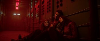 Movie still from “Resident Evil: Welcome to Raccoon City” (2021), directed by Johannes Roberts – A man and two women sitting on a bed; Medium shot, Low angle