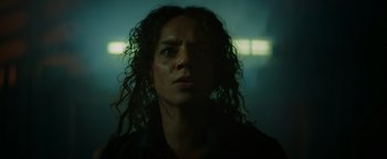 Movie still from “Resident Evil: Welcome to Raccoon City” (2021), directed by Johannes Roberts – A person with curly hair looking at the camera; Close Up shot, Low angle