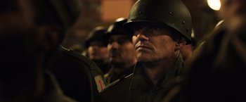 Movie still from “Resistance” (2020), directed by Jonathan Jakubowicz – A group of men in military fatigues and helmets; Close Up shot, Over the shoulder angle