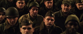 Movie still from “Resistance” (2020), directed by Jonathan Jakubowicz – A group of men in military fatigues sitting in a room; Medium shot, High angle