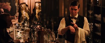 Movie still from “Resistance” (2020), directed by Jonathan Jakubowicz – A man standing in front of a bunch of empty glasses; Medium shot, Low angle