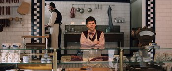 Movie still from “Resistance” (2020), directed by Jonathan Jakubowicz – A man standing behind a counter in a kitchen; Medium shot, Overhead angle