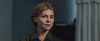 Movie still from “Resistance” (2020), directed by Jonathan Jakubowicz – A person wearing a green shirt; Close Up shot, Over the shoulder angle