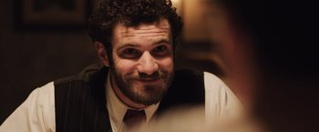 Movie still from “Resistance” (2020), directed by Jonathan Jakubowicz – A person wearing a suit and tie; Close Up shot, Over the shoulder angle