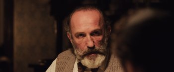 Movie still from “Resistance” (2020), directed by Jonathan Jakubowicz – An older man with a beard and a mustache; Close Up shot, Low angle