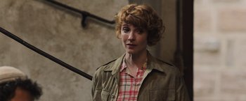 Movie still from “Resistance” (2020), directed by Jonathan Jakubowicz – A woman in a plaid shirt and a brown jacket; Close Up shot, Over the shoulder angle