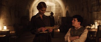 Movie still from “Resistance” (2020), directed by Jonathan Jakubowicz – A woman is looking down at a piece of paper; Medium shot, Over the shoulder angle