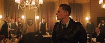 Movie still from “Resistance” (2020), directed by Jonathan Jakubowicz – A man wearing a leather jacket and a tie; Medium shot, Over the shoulder angle