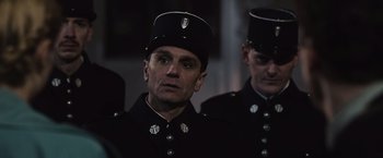 Movie still from “Resistance” (2020), directed by Jonathan Jakubowicz – A man in a black uniform wearing a black hat; Close Up shot, Over the shoulder angle