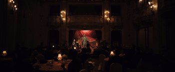 Movie still from “Resistance” (2020), directed by Jonathan Jakubowicz – A man is on stage in front of an audience; Extreme Wide shot, High angle