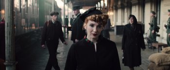 Movie still from “Resistance” (2020), directed by Jonathan Jakubowicz – A woman in a black coat and a hat; Medium shot, Over the shoulder angle