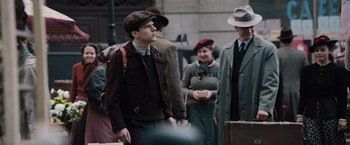 Movie still from “Resistance” (2020), directed by Jonathan Jakubowicz – A group of people standing next to each other on the street; Medium shot, Over the shoulder angle