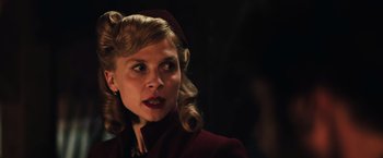 Movie still from “Resistance” (2020), directed by Jonathan Jakubowicz – A woman in a red coat and a red hat; Close Up shot, Low angle