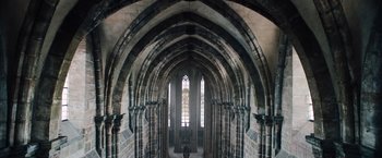 Movie still from “Resistance” (2020), directed by Jonathan Jakubowicz – An old cathedral with a stained glass window; Extreme Wide shot, High angle