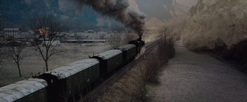 Movie still from “Resistance” (2020), directed by Jonathan Jakubowicz – A train traveling down train tracks near a forest; Extreme Wide shot, High angle