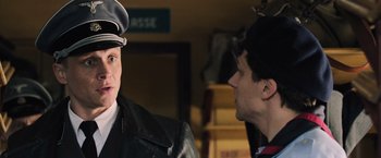 Movie still from “Resistance” (2020), directed by Jonathan Jakubowicz – A man in a black leather jacket talking to another man in a black leather jacket; Close Up shot, Over the shoulder angle