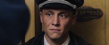 Movie still from “Resistance” (2020), directed by Jonathan Jakubowicz – A person wearing a hat; Close Up shot, High angle