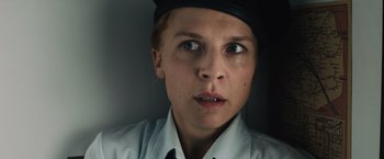 Movie still from “Resistance” (2020), directed by Jonathan Jakubowicz – A woman wearing a black hat and a white shirt; Close Up shot, Low angle