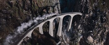 Movie still from “Resistance” (2020), directed by Jonathan Jakubowicz – An aerial view of a train traveling over a bridge; Extreme Wide shot, High angle