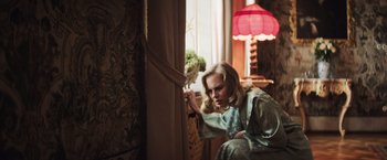 Movie still from “Resistance” (2020), directed by Jonathan Jakubowicz – A woman leaning up against a window sill; Medium shot, High angle