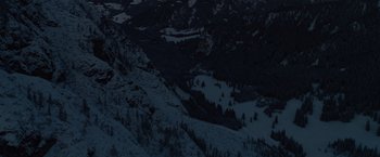 Movie still from “Resistance” (2020), directed by Jonathan Jakubowicz – A view of a snowy mountain range at night time; Extreme Wide shot, High angle