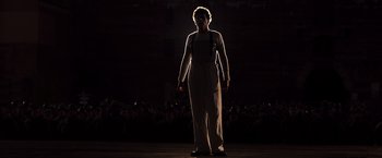 Movie still from “Resistance” (2020), directed by Jonathan Jakubowicz – A woman standing on a stage in front of an audience; Medium shot, Low angle