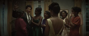Movie still from “Respect” (2021), directed by Liesl Tommy – A group of people standing around each other in a room; Medium shot, Over the shoulder angle