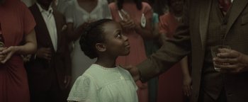 Movie still from “Respect” (2021), directed by Liesl Tommy – A young girl in a white dress looking up at an older man; Close Up shot, Over the shoulder angle