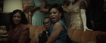 Movie still from “Respect” (2021), directed by Liesl Tommy – A man and a woman sitting next to each other on a couch; Medium shot, Low angle