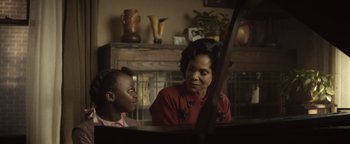 Movie still from “Respect” (2021), directed by Liesl Tommy – A woman and a boy sitting in front of a grand piano; Close Up shot, Over the shoulder angle