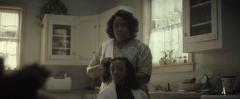 Movie still from “Respect” (2021), directed by Liesl Tommy – A woman cutting a young girl's hair in a kitchen; Close Up shot, Over the shoulder angle