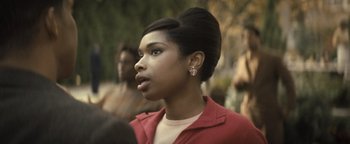 Movie still from “Respect” (2021), directed by Liesl Tommy – A woman in a red jacket is looking to her left; Close Up shot, Over the shoulder angle