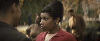 Movie still from “Respect” (2021), directed by Liesl Tommy – A woman in a red jacket is looking to her left; Close Up shot, Over the shoulder angle