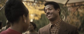 Movie still from “Respect” (2021), directed by Liesl Tommy – A man wearing a suit and tie talking to a woman in front of a tree; Close Up shot, Over the shoulder angle