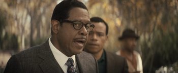 Movie still from “Respect” (2021), directed by Liesl Tommy – A man in a suit and tie next to another man in a suit and tie; Close Up shot, Over the shoulder angle