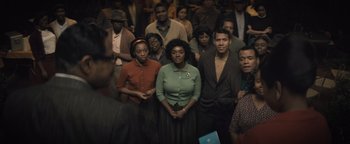 Movie still from “Respect” (2021), directed by Liesl Tommy – A group of people standing around each other; Medium shot, High angle