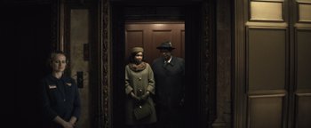 Movie still from “Respect” (2021), directed by Liesl Tommy – A man and a woman standing next to each other in front of an elevator; Medium shot, Low angle