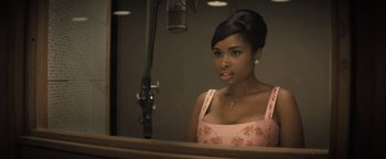 Movie still from “Respect” (2021), directed by Liesl Tommy – A beautiful young woman in a pink dress looking into a mirror; Close Up shot, High angle