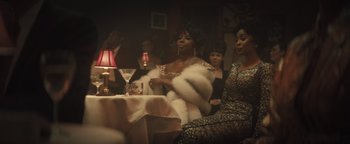 Movie still from “Respect” (2021), directed by Liesl Tommy – A group of women sitting at a table with a glass of wine; Medium shot, Over the shoulder angle