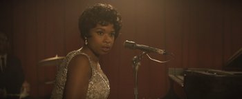 Movie still from “Respect” (2021), directed by Liesl Tommy – A woman standing next to a microphone in front of a microphone stand; Close Up shot, Over the shoulder angle