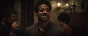 Movie still from “Respect” (2021), directed by Liesl Tommy – A person wearing a suit and tie; Close Up shot, Over the shoulder angle