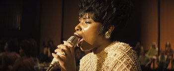 Movie still from “Respect” (2021), directed by Liesl Tommy – A woman is singing into a microphone; Close Up shot, Low angle
