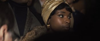 Movie still from “Respect” (2021), directed by Liesl Tommy – A person wearing a gold hat; Close Up shot, Over the shoulder angle