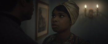 Movie still from “Respect” (2021), directed by Liesl Tommy – A woman wearing a head scarf looking at the camera; Close Up shot, Over the shoulder angle