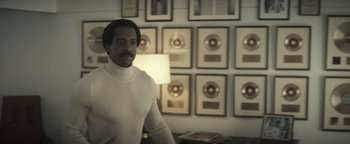 Movie still from “Respect” (2021), directed by Liesl Tommy – A man standing in front of a row of records; Medium shot, Low angle