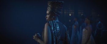 Movie still from “Respect” (2021), directed by Liesl Tommy – A woman wearing a headdress and a dress; Medium shot, Over the shoulder angle