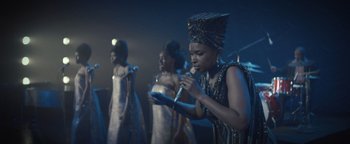Movie still from “Respect” (2021), directed by Liesl Tommy – A group of women singing on stage with microphones; Medium shot, Low angle