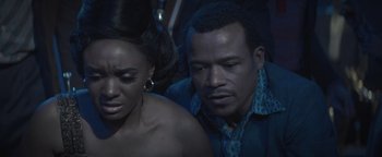 Movie still from “Respect” (2021), directed by Liesl Tommy – A man and a woman sitting next to each other in a dark room; Close Up shot, High angle